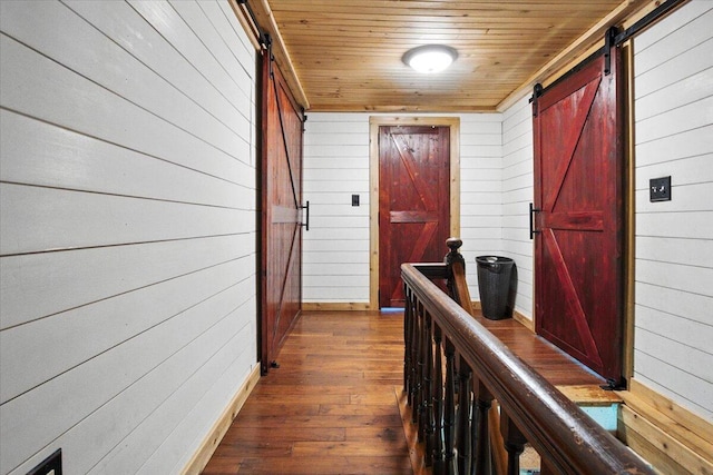 817 Riverside Dr, Augusta, ME 04330 - hallway with a barn door, wood walls, dark wood-style flooring, and wooden ceiling