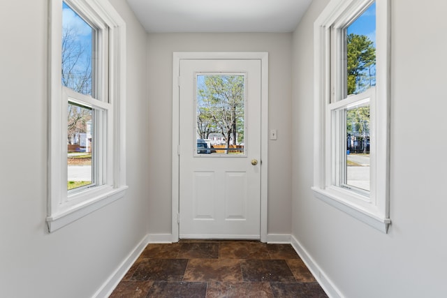 entryway with baseboards, stone finish flooring, and a wealth of natural light