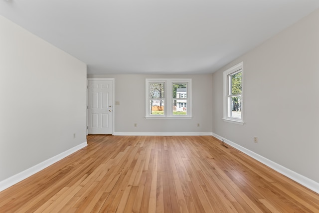 unfurnished room featuring baseboards, visible vents, and light wood-style flooring