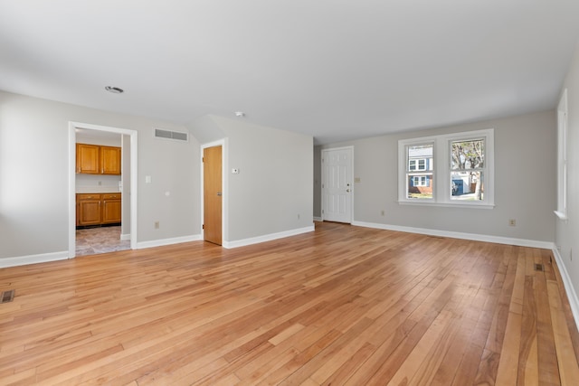 unfurnished living room featuring baseboards, light wood-style flooring, and visible vents