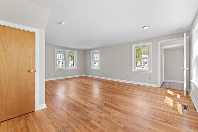 unfurnished living room featuring baseboards, light wood finished floors, and visible vents