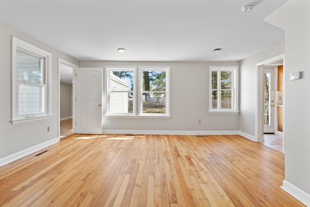 unfurnished room with baseboards and light wood-style flooring