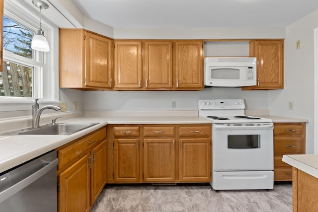 kitchen with brown cabinets, hanging light fixtures, a sink, white appliances, and light countertops