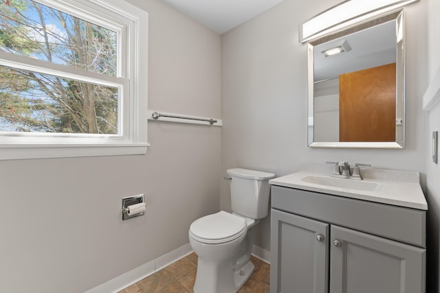 bathroom with baseboards, toilet, and vanity