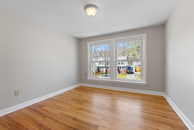 empty room featuring baseboards and light wood-style flooring