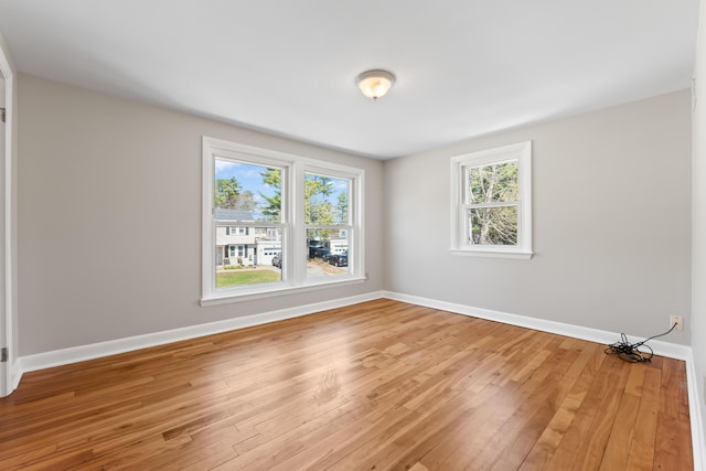 empty room with baseboards and hardwood / wood-style flooring