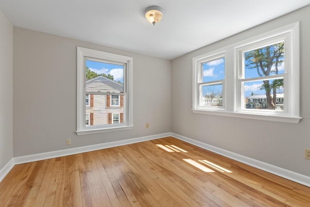 unfurnished room featuring baseboards and light wood-style floors