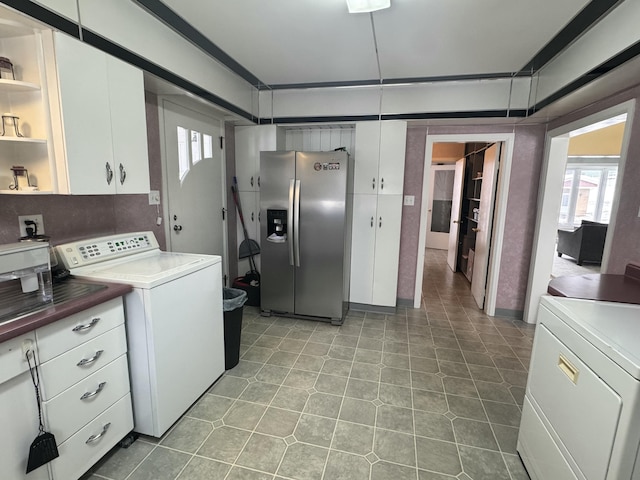 washroom with light tile patterned floors, washer / clothes dryer, and plenty of natural light
