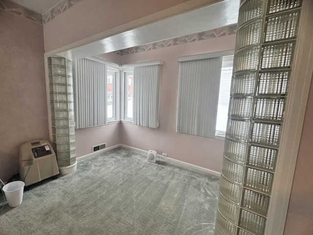 unfurnished room featuring baseboards, visible vents, carpet floors, and a healthy amount of sunlight