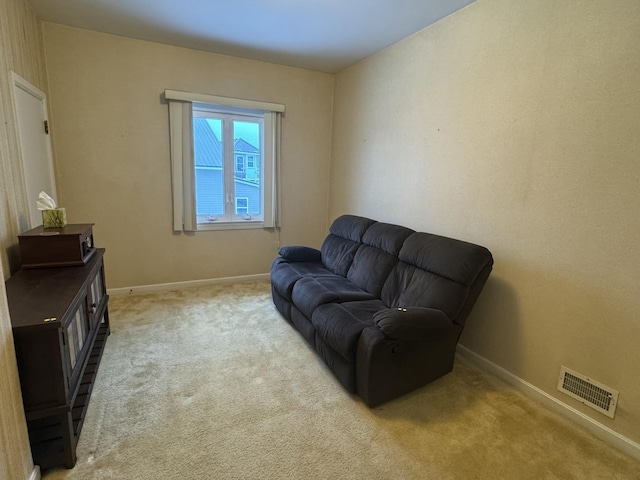 living area featuring light colored carpet, baseboards, and visible vents