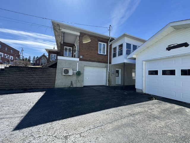 view of property exterior featuring an attached garage and aphalt driveway