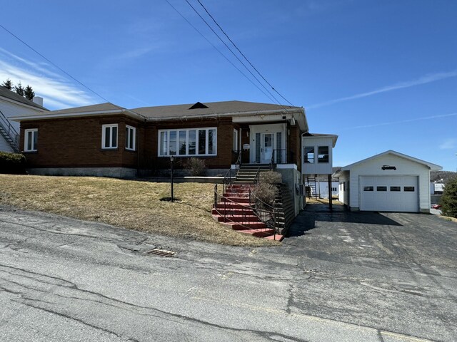 single story home featuring aphalt driveway and a garage