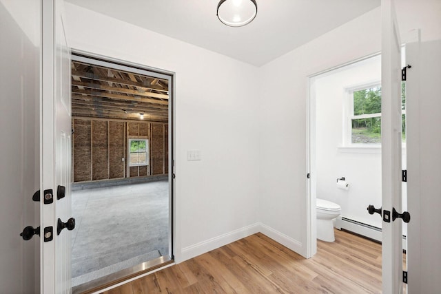 LOT87-1-2 Drown Rd, Alfred, ME 04002 - bathroom with toilet, a baseboard radiator, a healthy amount of sunlight, and wood finished floors