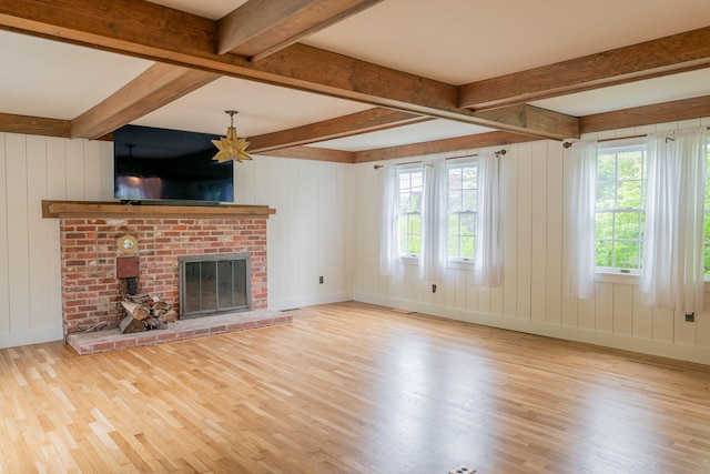 228 Atlantic Ave, Boothbay Harbor, ME 04538 - unfurnished living room with wood finished floors, beam ceiling, and a brick fireplace