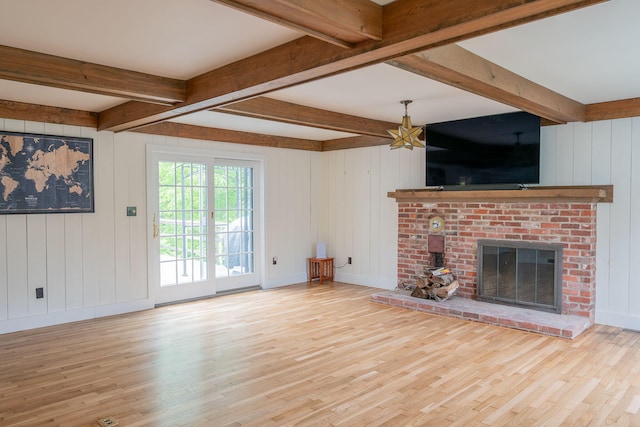228 Atlantic Ave, Boothbay Harbor, ME 04538 - unfurnished living room with wood finished floors, a fireplace, beam ceiling, and a decorative wall
