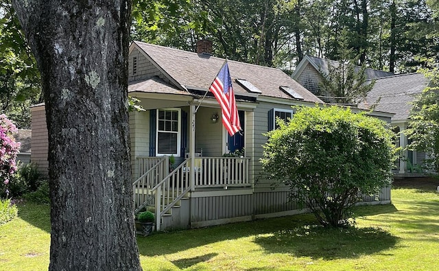 241 Berwick Rd, Ogunquit, ME 03907 - view of front facade with a front lawn, roof with shingles, and a chimney