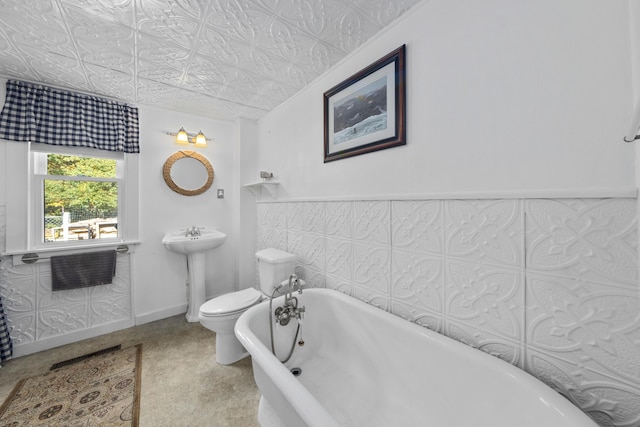 bathroom featuring a freestanding bath, an ornate ceiling, and toilet