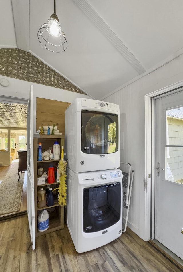 laundry area featuring stacked washer and dryer, wood finished floors, and laundry area