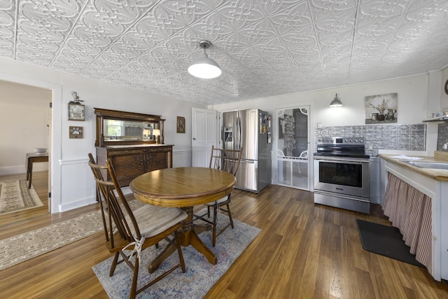 dining space with dark wood finished floors and an ornate ceiling