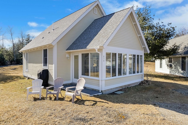rear view of house with roof with shingles