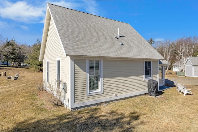 rear view of property featuring a yard and a shingled roof