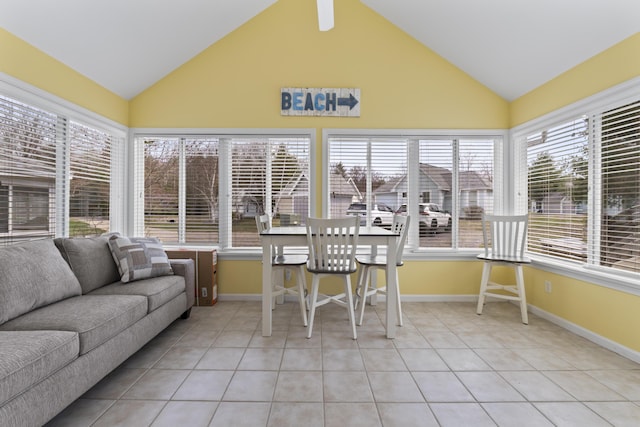 sunroom / solarium featuring tile patterned floors, lofted ceiling, and baseboards