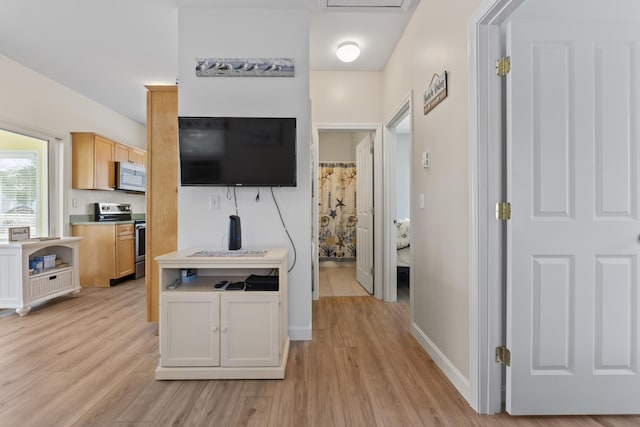hallway with light wood finished floors and baseboards