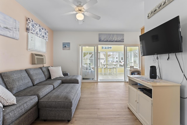 living room featuring light wood-style floors, a ceiling fan, and a wall mounted AC