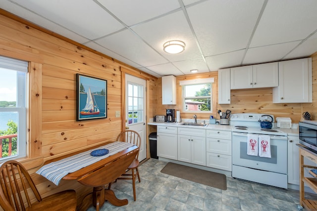 43 W Shore Rd, Harpswell, ME 04003 - kitchen with white electric range, a drop ceiling, light countertops, wooden walls, and a sink