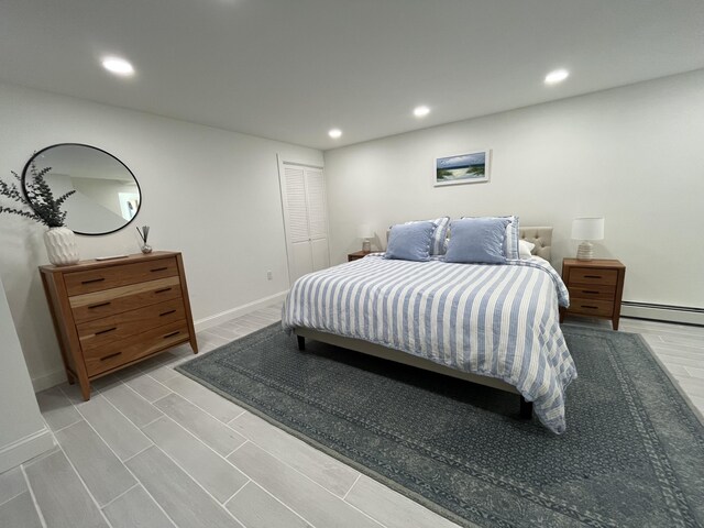 bedroom with recessed lighting, wood tiled floor, baseboards, and a baseboard heating unit