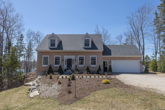 cape cod house featuring driveway, a shingled roof, a front lawn, and a garage