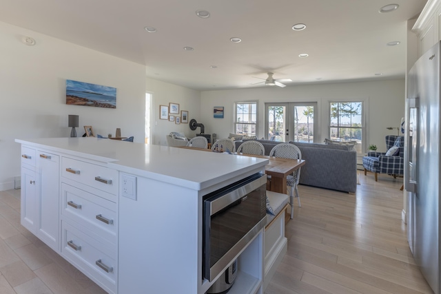 kitchen with ceiling fan, appliances with stainless steel finishes, white cabinets, open floor plan, and recessed lighting