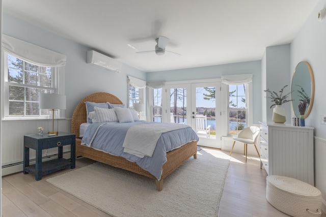bedroom featuring access to exterior, french doors, multiple windows, and a wall mounted air conditioner