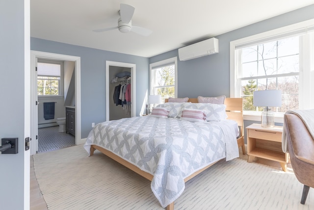 bedroom with connected bathroom, an AC wall unit, a baseboard heating unit, and multiple windows