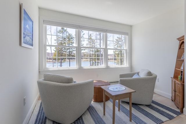 living area with baseboards and a baseboard heating unit