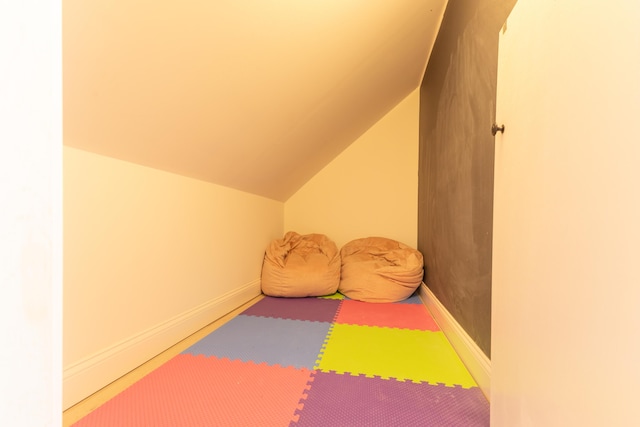 rec room with baseboards and vaulted ceiling