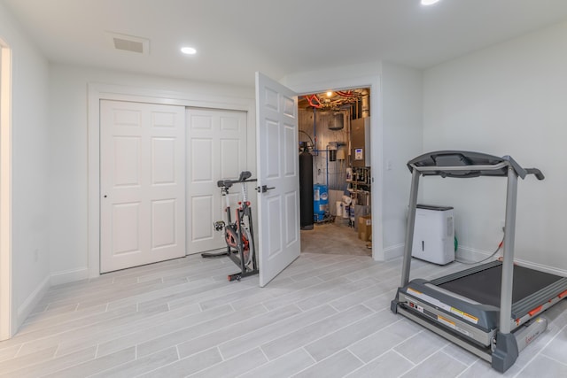 exercise room with recessed lighting, baseboards, visible vents, and light wood-style floors