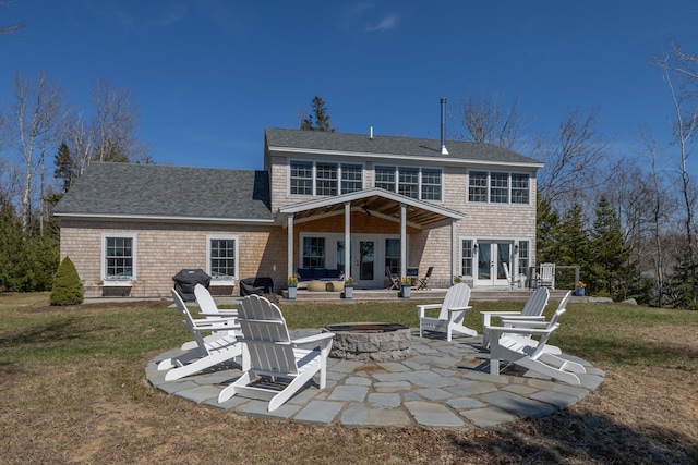 rear view of property featuring a yard, french doors, a patio area, and an outdoor fire pit