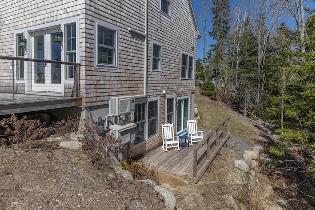 view of property exterior featuring an AC wall unit, a wooden deck, and french doors