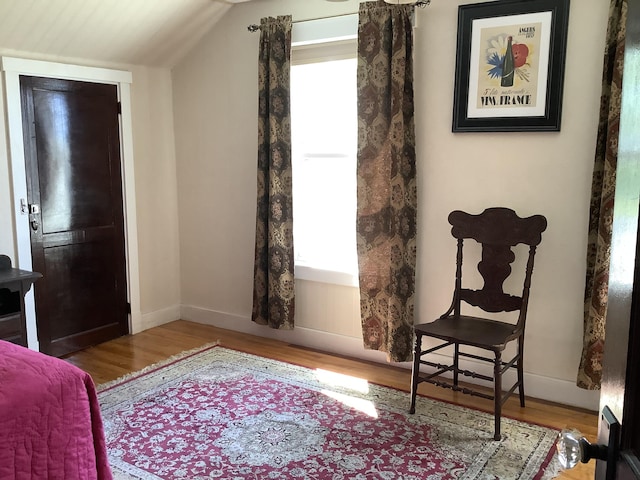 sitting room with vaulted ceiling, wood finished floors, and baseboards