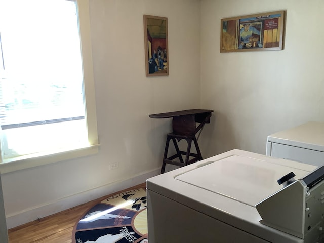 laundry room featuring separate washer and dryer, baseboards, laundry area, and light wood-type flooring
