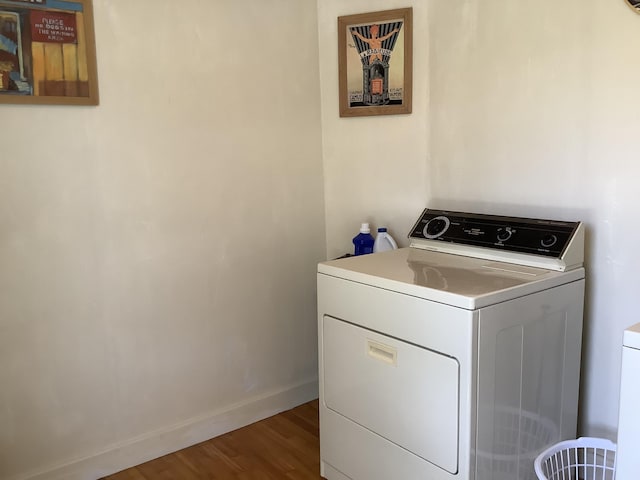 laundry area with baseboards, wood finished floors, laundry area, and washer / clothes dryer