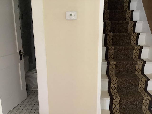 stairway with tile patterned floors