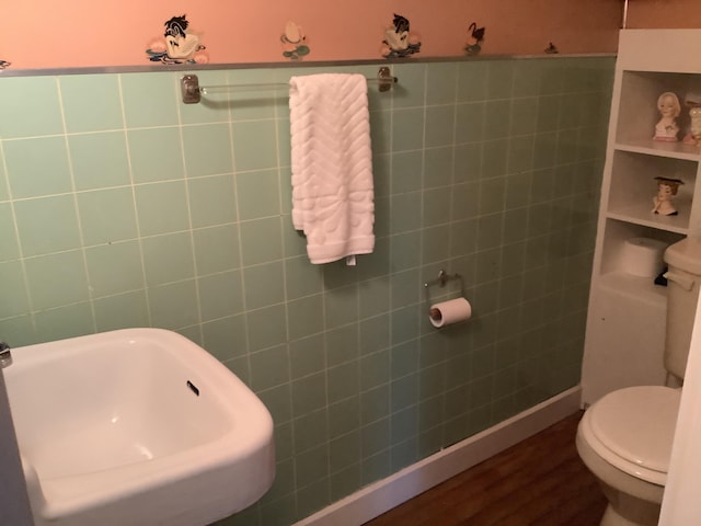bathroom with wood finished floors, toilet, and a sink