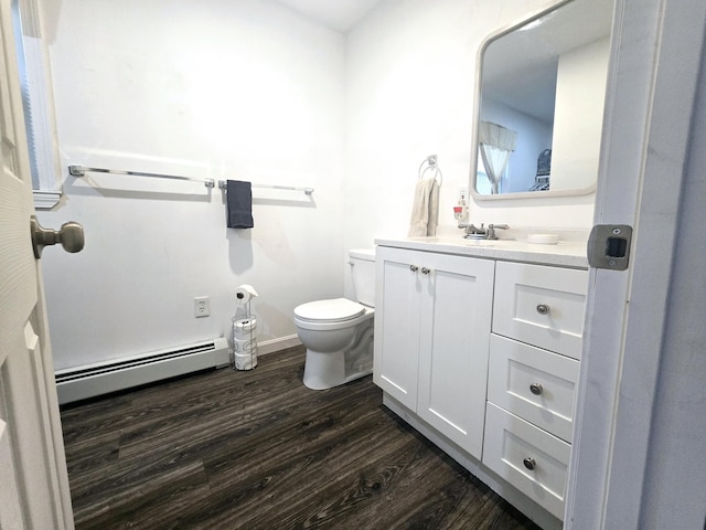 bathroom featuring baseboard heating, wood finished floors, vanity, and toilet