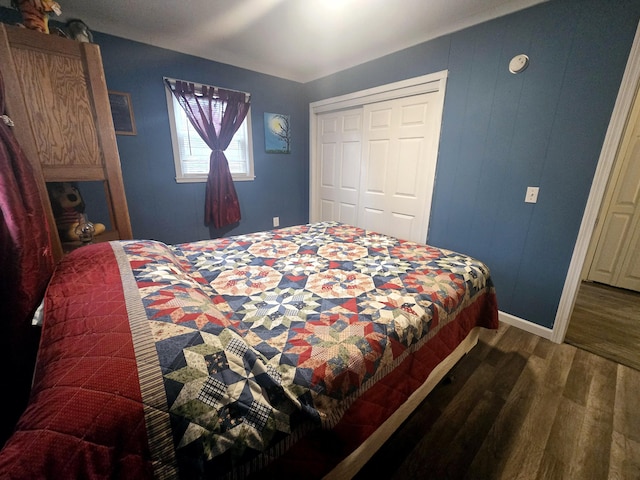 bedroom featuring baseboards, wood finished floors, and a closet