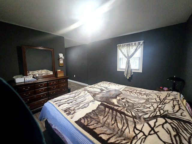 bedroom featuring baseboards and wood finished floors
