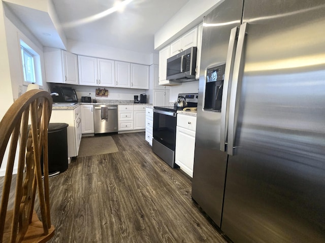 kitchen with stainless steel appliances, light countertops, dark wood-type flooring, and white cabinetry