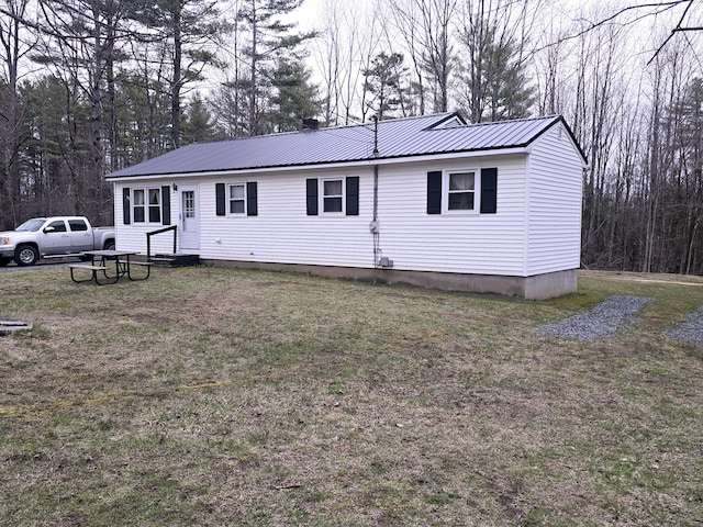 view of front of home featuring a front lawn and metal roof