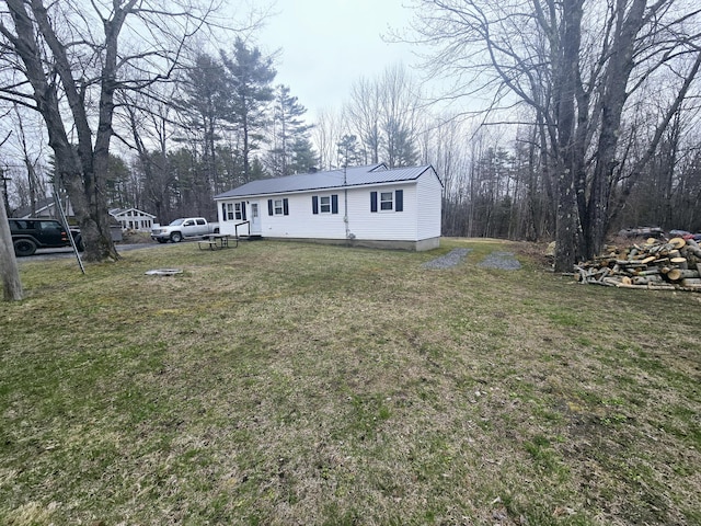view of front facade featuring a front lawn and metal roof